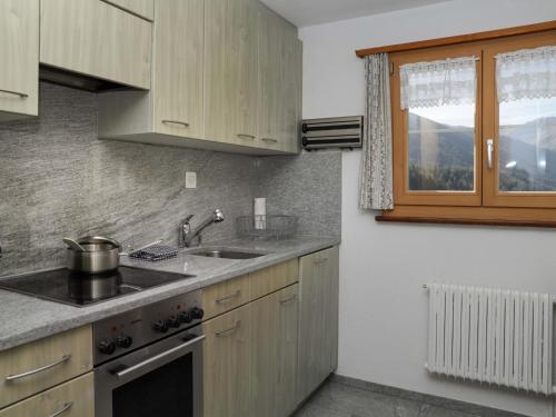 FrauenkirchApartment Haus Chumma Apt1 by Interhome的厨房配有木制橱柜、水槽和窗户。