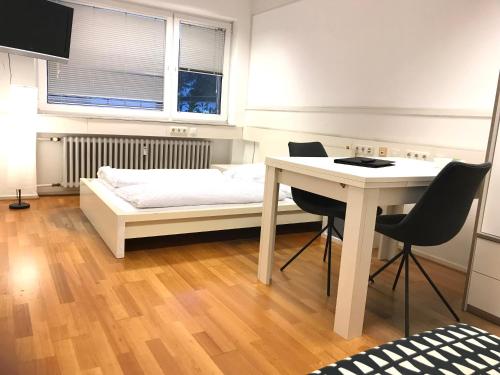 亚琛Relax Aachener Boardinghouse Budget的一间卧室配有一张床、一张桌子和一张桌子