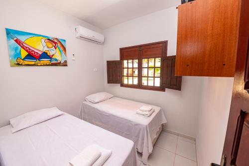 马拉戈日Residencial Maragogi的小房间设有两张床和窗户