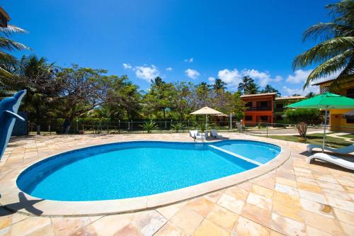 马拉戈日Residencial Maragogi的一个带椅子和遮阳伞的游泳池