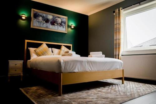 巴洛赫Lomond Park Hotel的一间卧室设有一张带绿色墙壁和窗户的床。