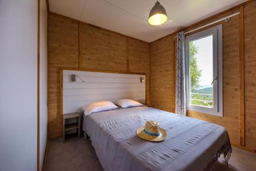维琪奥港Camping U Pirellu的一间卧室,配有一张床,上面有帽子