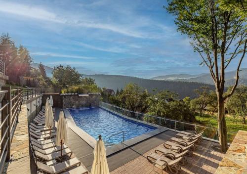 亚列姆切Ведмежа гора Panorama Spa Resort的一个带躺椅的游泳池,享有山景