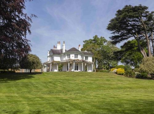 BuckinghamshireDenham Mount的郁郁葱葱的绿色田野上的大型白色房屋