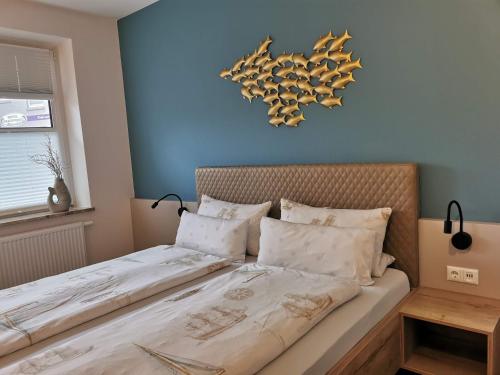 库克斯港戴赫沃格特酒店的一间卧室配有带白色床单和枕头的床。