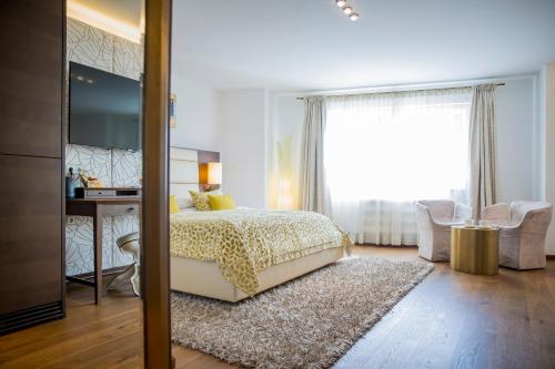 蒙德塞Iris Porsche Hotel & Restaurant的一间卧室配有一张床、一张书桌和一个窗户。