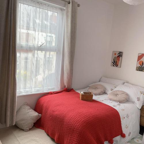 ParksideMonk’s Lodge的一间卧室配有一张带红色毯子的床和窗户。