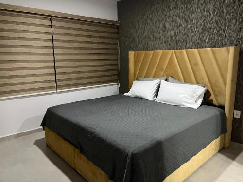 马萨特兰Bluu Habitat Lagoons的一间卧室配有一张带木制床头板的床