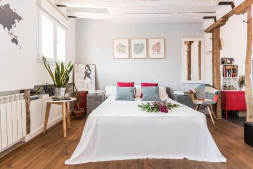 马德里Charming La Latina Home的白色卧室设有一张大床和一张沙发