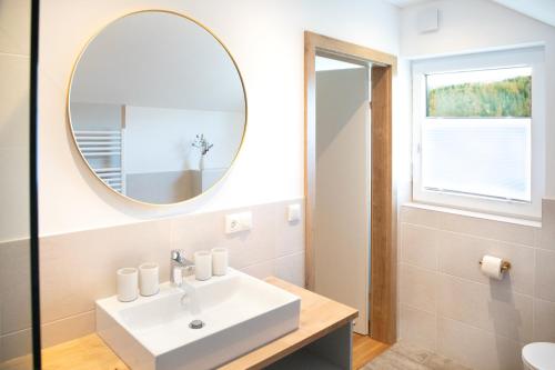 施特罗布尔Moosaik Appartements的一间带水槽和镜子的浴室