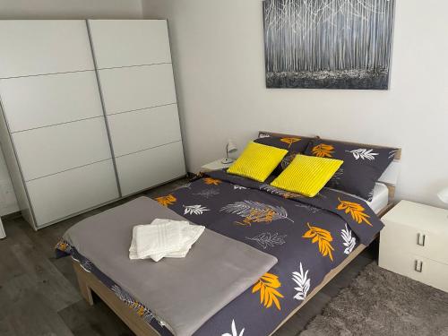 瓦拉日丁ASTORIA的一间卧室配有一张带黄色枕头的床