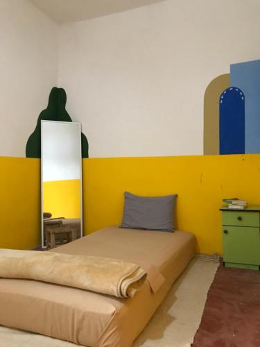 阿加迪尔Green IGR Guesthouse的一间卧室配有一张黄色床头板的床
