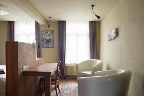 BeverPoëziehotel Surplace的客房设有桌子、椅子和床。