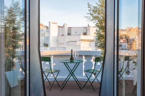 里斯本Haws Lisboa的阳台的窗户享有风景,配有桌椅。