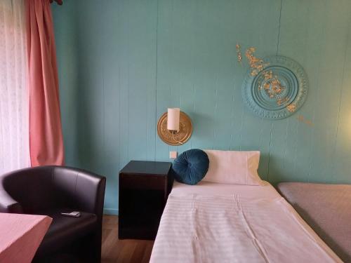 特罗Motel的小房间设有一张床和一把椅子