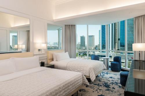 迪拜Le Meridien Mina Seyahi Beach Resort & Waterpark的酒店客房设有两张床和大窗户。