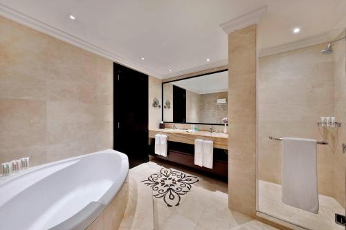 迪拜Le Meridien Mina Seyahi Beach Resort & Waterpark的带浴缸和盥洗盆的浴室