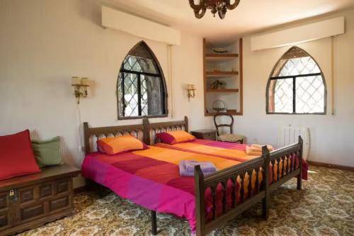 阿维拉ISLA DEL BURGUILLO的一间卧室设有一张大床和两个窗户。