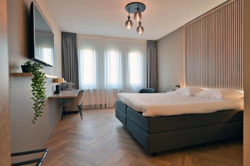 阿尔克马尔Hotel Alkmaar的一间卧室配有一张床和一张书桌