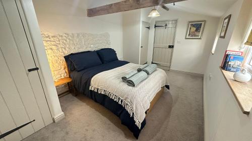 沃明斯特Rural Retreat, Wood Burner, Patio, Lawn, Breakfast, new wifi的小卧室配有带蓝色枕头的床