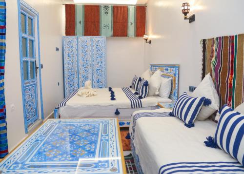 舍夫沙万CASA BLUE PEARL的蓝色和白色的客房内的三张床