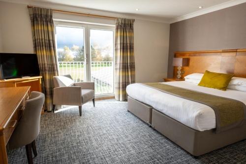Ticehurst戴尔赫拉酒店的酒店客房设有一张床和一个阳台。