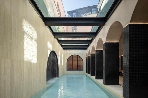 阿威罗MS Collection Aveiro - Palacete Valdemouro的一座带玻璃天花板的建筑中的游泳池