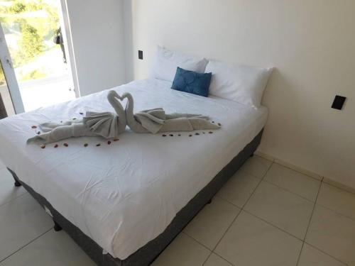 French HarborCoral Views Resort - Villa uMaMi的一间卧室配有一张带白色床单的床和一扇窗户。