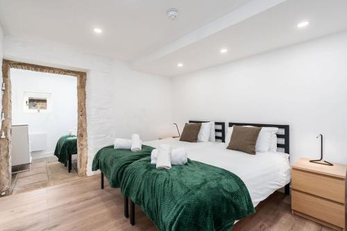 TissingtonDovedale Manor 8 Bedrooms的卧室设有两张床,拥有白色的墙壁和木地板