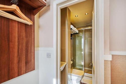 伦敦Huttons Hotel, Victoria London的带淋浴的浴室和步入式衣柜。
