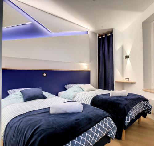 圣马洛Escalier 16 - 30 m plage du Sillon - Proche Intra的卧室内的两张床,配有蓝色床头板