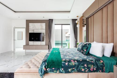 农布Astro Deluxe 4 Bedrooms Villa的一间卧室配有一张大床和电视