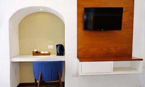 普埃布拉Casa Pepe的客房设有壁挂式电视、桌子和椅子。