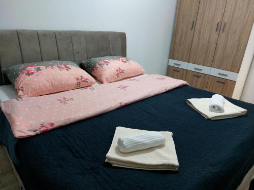 布戈伊诺Apartman-Stan的一张带粉红色床单和毛巾的床