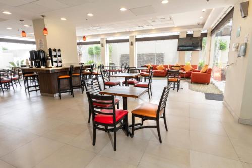 瓜达拉哈拉快捷假日酒店瓜达拉哈拉机场酒店的餐厅设有桌椅和沙发。