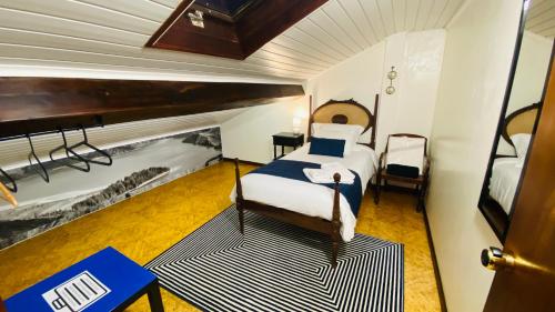 蓬塔德尔加达Alojamento CANTO NA RELVA的一间卧室配有一张床和一架钢琴