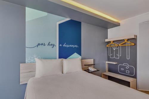 伊拉普阿托One Irapuato的一间卧室设有一张床和蓝色的墙壁