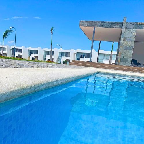 曼塔Casa Familiar a Pasos del Mar Playa y Felicidad的大楼前的蓝色游泳池