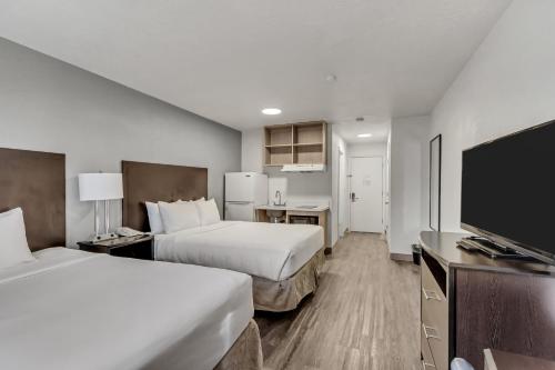 盐湖城Clarion Inn Salt Lake City Airport的酒店客房设有两张床和一台平面电视。