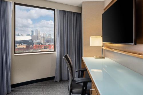 明尼阿波利斯明尼阿波利斯市中心万怡酒店的酒店客房设有一张书桌和一个大窗户。