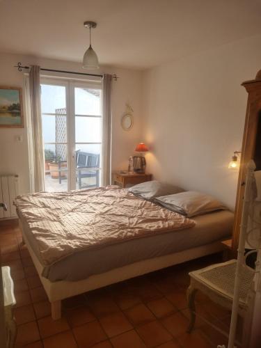 蒙利沃Chambre d'hôte Montlivault / Chambord的一间卧室设有一张床和一个带庭院的窗户。