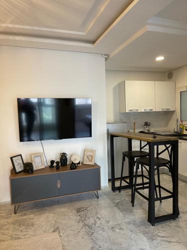 La SoukraLuxueux appart à 5 min de l'aéroport的厨房配有壁挂式大屏幕平面电视。