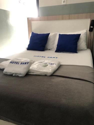 圣保罗Hotel sany - Localizado à 5 minutos do Metrô Paulista的一张带蓝色和白色枕头的床