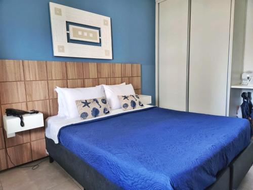 里约热内卢Apartamento Barra Pé na Areia的蓝色卧室配有一张带蓝色床单的大床
