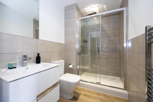 曼彻斯特Chic Luxury Apartment near Old Trafford Stadiums Manchester的带淋浴、卫生间和盥洗盆的浴室