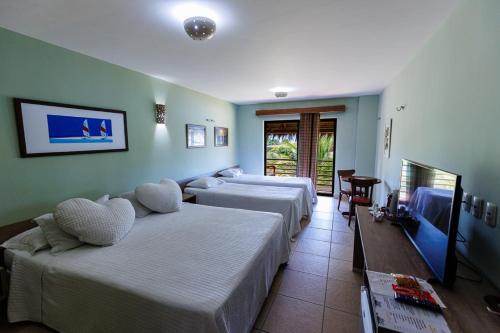路易斯科雷亚Carnaubinha Praia Resort的酒店客房设有两张床和一张桌子。