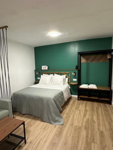 阿尔科斯-德拉弗龙特拉SlowHome Arcos的一间卧室设有一张大床和绿色的墙壁