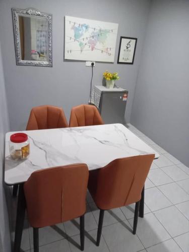 拉布安Orchid Homestay的客房内的白色桌子和橙色椅子