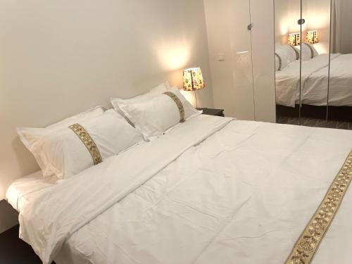 StabekkScandpoint Apartment Fornebu Near Sea front with outdoor walk!的白色的床、白色枕头和镜子