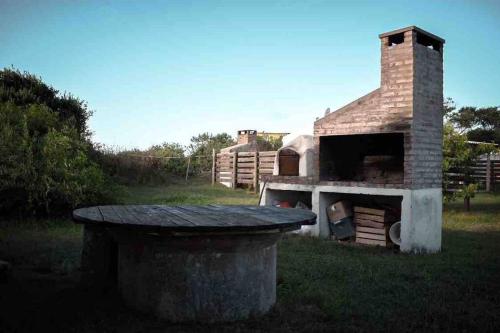 巴拉德瓦利扎斯Casa en Valizas a 250m del mar的院子里的砖炉,有垃圾桶